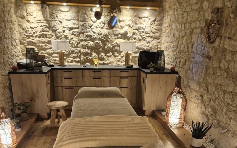 La salle de soin du cabinet de réflexologie, dans une cave voûtée en pierre éclairée d'une lumière douce